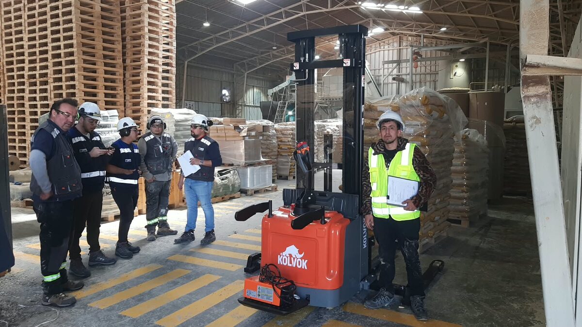 Equipo de trabajo con un apilador Kolvok en una bodega